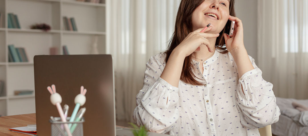 Mujer habla por teléfono mientras trabaja